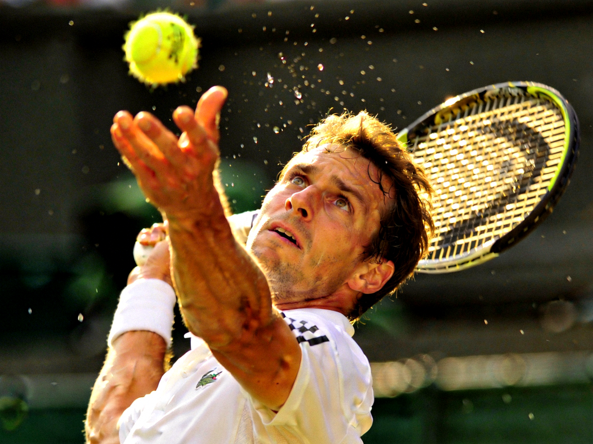 男子网球选手发球时专注的神情与动作特写